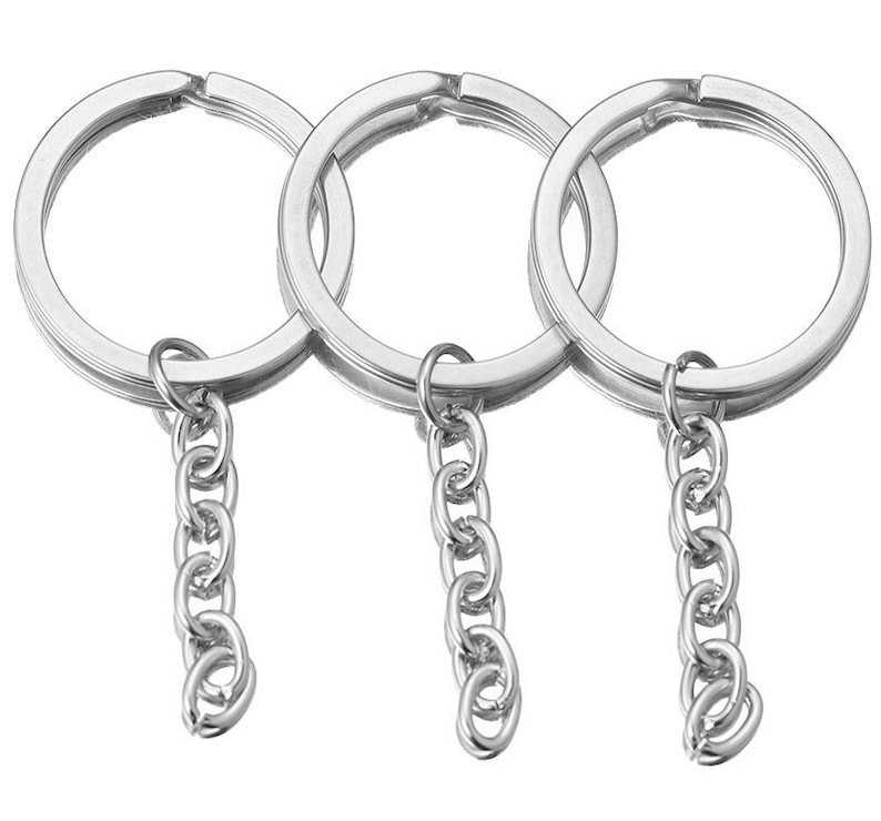 May include: Three silver keychains with attached chains. Each keychain is a simple circle.