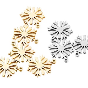 Op de afbeelding: Een set met gouden en zilveren sneeuwvlokcharms. De charms zijn gemaakt van metaal en hebben een delicaat, ingewikkeld ontwerp. Ze zijn perfect om een vleugje winterse magie toe te voegen aan je sieraden of knutselwerk.