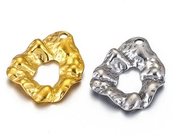 May include: Two metal pendants with a textured, organic shape and a hole in the center. One pendant is gold and the other is silver.