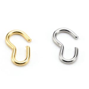 Puede incluir: Dos anillos de salto de metal, uno dorado y otro plateado. Los anillos están abiertos y listos para ser unidos a una cadena u otras joyas.