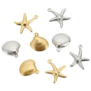 Può includere: Una collezione di ciondoli in metallo color oro e argento con conchiglie e stelle marine. I ciondoli hanno una superficie testurizzata e sono perfetti per la creazione di gioielli.