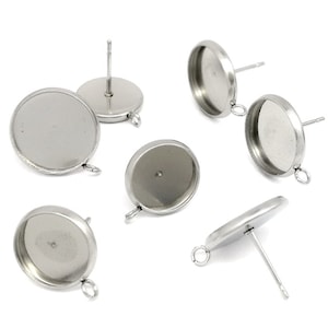 May include: Six silver-toned earring settings with round bezels. The bezels are designed to hold a cabochon stone or other embellishment.