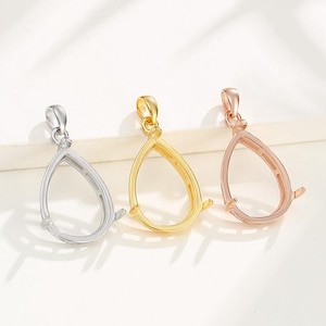 Könnte beinhalten: Drei tropfenförmige Anhänger-Einstellungen in Silber, Gold und Roségold. Jede Einstellung hat eine glatte, abgerundete Kante und eine Öse zum Anbringen einer Kette.