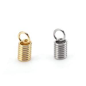 May include: Two metal cord end caps, one gold and one silver. Each cap has a small loop at the top and a coiled spring design.