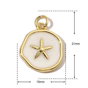 K&ouml;nnte beinhalten: Goldfarbener Anh&auml;nger mit einem wei&szlig;en Emaille-Seestern-Design. Der Anh&auml;nger hat einen Durchmesser von 15 mm und eine H&ouml;he von 21 mm.