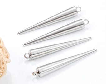 Puede incluir: Cuatro colgantes plateados en forma de cono, con un lazo en la parte superior para sujetarlos a una cadena u otro componente de joyería. Los colgantes son lisos y pulidos, con un diseño cónico.