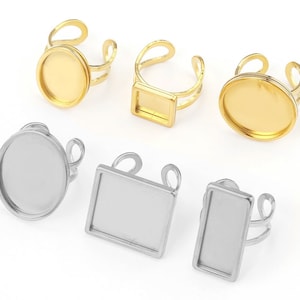 Könnte beinhalten: Sechs verstellbare Ringrohlinge mit runden und quadratischen Einfassungen. Drei sind golden und drei sind silbern.