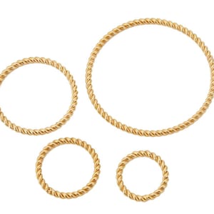 Puede incluir: Cuatro anillos dorados con un diseño de cuerda trenzada de diferentes tamaños. Los anillos están dispuestos sobre un fondo blanco. Probablemente sean joyas, posiblemente pendientes o colgantes.