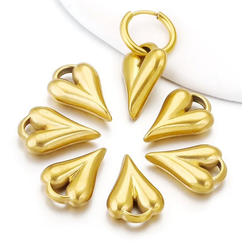 May include: Seven gold-colored heart-shaped charms with a ring attached to one of the charms.
