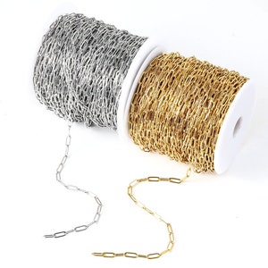 Puede incluir: Dos carretes de cadena, uno plateado y otro dorado. La cadena es de estilo simple, plana, de eslabones ovalados.