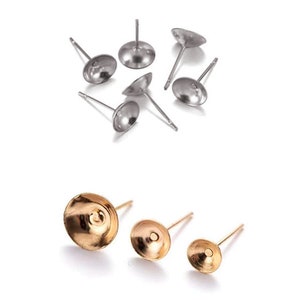 Könnte beinhalten: Ein Satz Ohrring-Findings in Silber und Gold. Die silbernen Findings sind rund mit einer flachen Oberseite und einem Stift. Die goldenen Findings sind rund mit einer flachen Oberseite und einem Stift. Die Findings dienen zum Anbringen von Ohrringen.