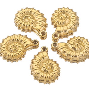 May include: Five gold-coloured ammonite shell charms with a detailed, textured surface. Each charm has a loop for attaching to jewellery or other crafts.
