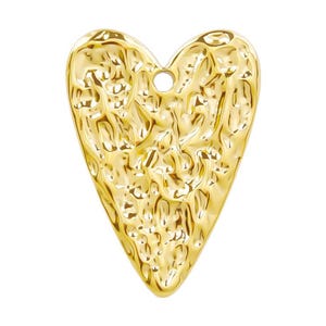 May include: A gold-colored heart-shaped pendant with a textured surface. The pendant has a hole at the top for attaching a chain or cord.
