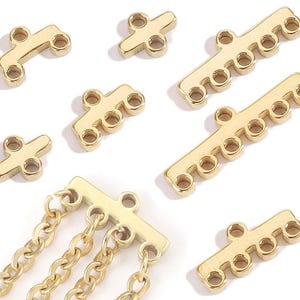 May include: Gold-colored jewelry findings in various shapes. Includes bar connectors with multiple holes and cross-shaped pieces, along with a gold chain. These findings are used for jewelry making and crafting.