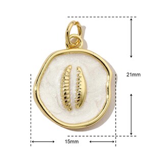 K&ouml;nnte beinhalten: Goldener Anh&auml;nger mit einem wei&szlig;en Emaille-Kreis, der mit zwei goldenen Blattmotiven verziert ist. Der Anh&auml;nger hat einen Durchmesser von 15 mm und eine H&ouml;he von 21 mm.