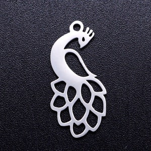 May include: Silver metal charm shaped like a peacock with its tail feathers spread out. The charm is detailed and intricate.