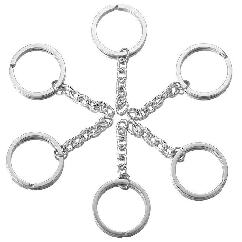 May include: Six silver key rings with attached chains, arranged in a starburst pattern.