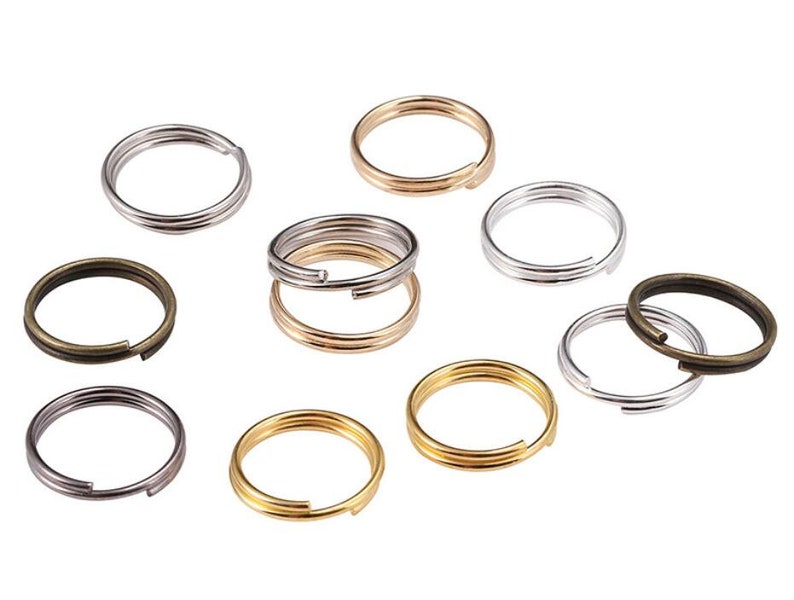 Pu&ograve; includere: Assortimento di portachiavi in argento, oro e bronzo. I portachiavi sono di diverse dimensioni e tutti aperti.