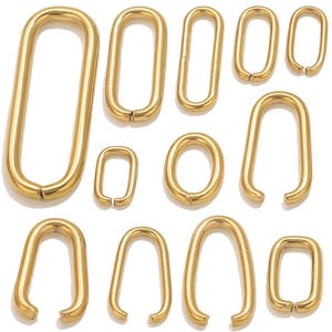 Può includere: Una collezione di anelli ovali in metallo dorato di varie dimensioni. Gli anelli sono aperti a un'estremità e il metallo ha una superficie lucida e riflettente. La disposizione comprende forme allungate e arrotondate, adatte per gioielli o progetti artigianali.