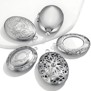 Pode incluir: Cinco pingentes de medalhão ovais de prata com designs diferentes. Os medalhões têm uma abertura com dobradiças e um laço para prender uma corrente.