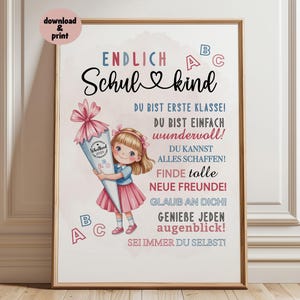 May include: A framed print with the words "ENDLICH Schulkind" in black script, with a cartoon girl holding a school cone. The print has a light background with colorful text and ABC letters. The girl is wearing a pink skirt and blue shirt.