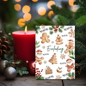 May include: A white card with a Christmas invitation design. The card features gingerbread men, Christmas trees, snowflakes, and the text "Einladung" which means "Invitation" in German. The card is surrounded by greenery and a red candle.