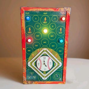 May include: Vintage baseball game with a green and red painted metal exterior. The game features a baseball diamond clock, lights, and the words "OUT" and "HIT". The game has a score board on the side.
