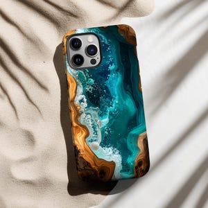 May include: A phone case with a unique design featuring a blend of teal, blue, and white colors, resembling an abstract ocean scene. The case has a wooden-like border in shades of brown and gold.