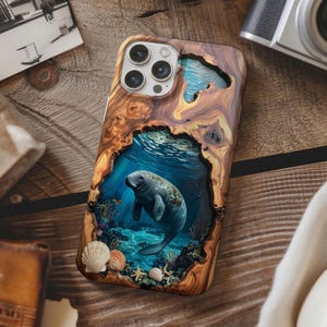 May include: A wooden phone case featuring a manatee swimming underwater. The case has a natural wood grain pattern with a cutout revealing the manatee scene. Seashells and starfish are at the bottom of the case.