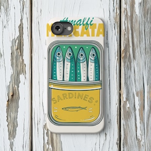 May include: A white phone case featuring a sardine can design. The can is yellow and green, with the word "SARDINES" and a fish illustration. The top of the case has the words "Amalfi" and "Mescata" in green and yellow.