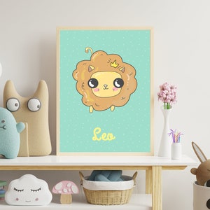Puede incluir: Un estampado enmarcado con un león de dibujos animados con una corona y la palabra "Leo" debajo. El león es de color marrón claro con una cara amarilla y ojos grandes, sobre un fondo azul claro con puntos. El estampado está en un estante blanco con juguetes.