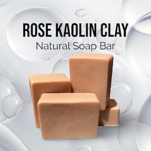 May include: Four bars of rose kaolin clay soap. The soap is a light pink color and has a natural, earthy look. The soap is stacked on top of each other, with the largest bar on the bottom and the smallest bar on top. The soap is sitting on a white background.