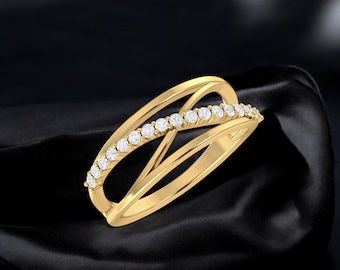 Könnte beinhalten: Ein goldener Ring mit einem filigranen, ineinander verschlungenen Design. Der Ring ist mit einer Reihe kleiner, klarer Diamanten besetzt.