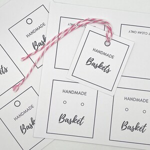 Pode incluir: Uma folha de papel branco com v&aacute;rias etiquetas de presente em branco. As etiquetas s&atilde;o quadradas e t&ecirc;m uma borda preta. As etiquetas t&ecirc;m o texto "Handmade Baskets" impresso nelas.