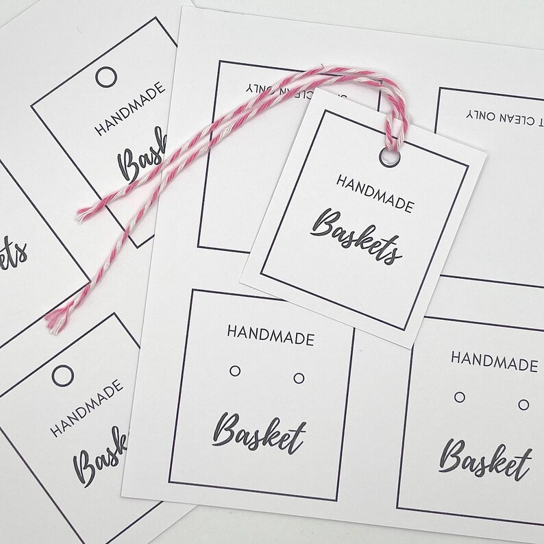 Pode incluir: Uma folha de papel branco com v&aacute;rias etiquetas de presente em branco. As etiquetas s&atilde;o quadradas e t&ecirc;m uma borda preta. As etiquetas t&ecirc;m o texto "Handmade Baskets" impresso nelas.
