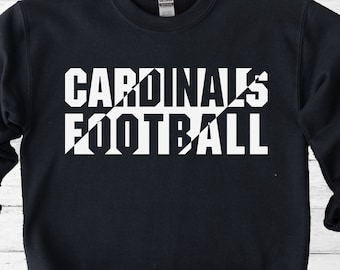 Puede incluir: Sudadera negra con texto blanco que dice "CARDINALS FOOTBALL" con una línea diagonal a través del texto.