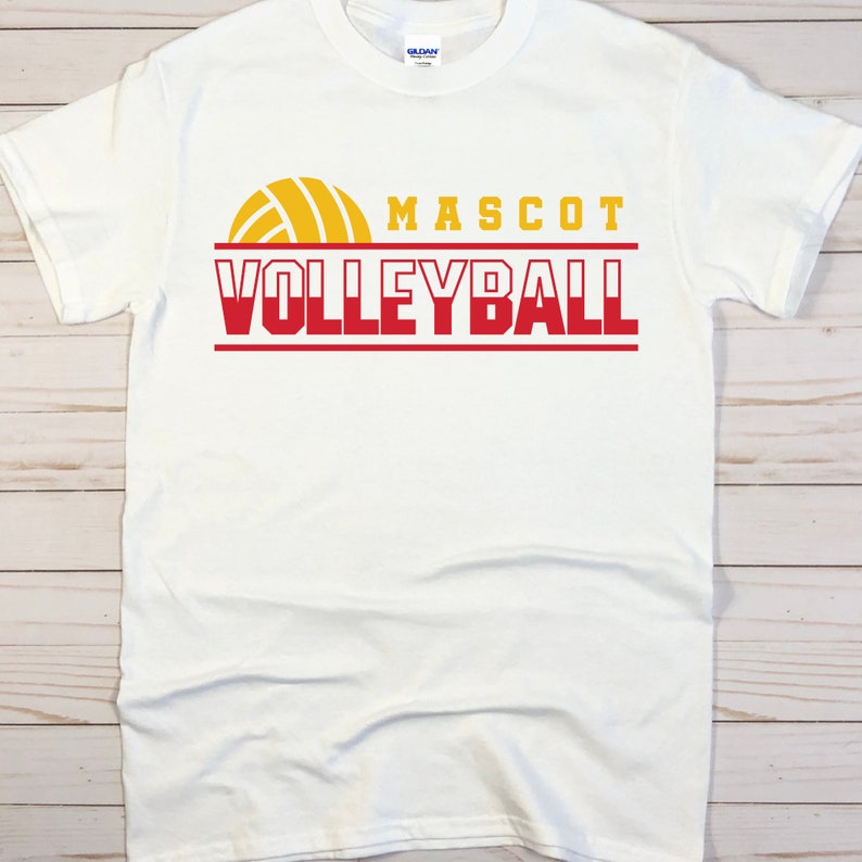May include: White t-shirt with a red and yellow volleyball graphic and the text "MASCOT VOLLEYBALL".