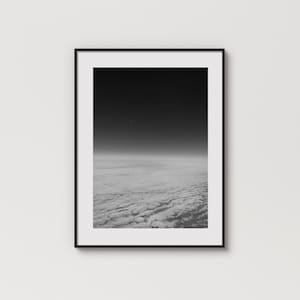 以下が含まれることがあります： 遠くの星が1つ見える、曇り空の白黒写真です。