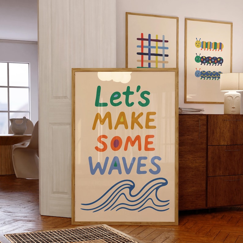 Puede incluir: Una impresi&oacute;n art&iacute;stica enmarcada con las palabras "Let's MAKE SOME WAVES" en letras coloridas, con ilustraciones de olas azules. Otras dos impresiones enmarcadas presentan dise&ntilde;os geom&eacute;tricos y de orugas coloridas. Las impresiones est&aacute;n en una habitaci&oacute;n con piso de madera.