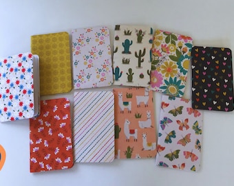 May include: Ten small notebooks with different patterned covers. The covers feature designs such as flowers, cacti, llamas, butterflies, and hearts.