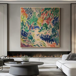 May include: Abstract landscape painting in a gold frame. The artwork uses a vibrant palette of blues, greens, reds, and yellows, creating a textured, brushstroke-style composition. The painting is displayed above a fireplace in a modern living room setting.