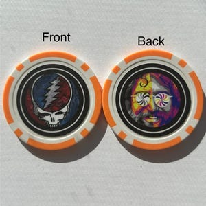 May include: Two poker chips with orange and white edges. One chip features a skull with a lightning bolt design, the other chip has a colorful portrait of a man with psychedelic glasses. The word "Front" and "Back" are printed on the image.