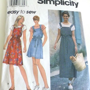May include: Simplicity sewing pattern featuring three dress designs. The pattern includes a red floral print dress, a blue denim dress, and a long plaid dress. The text "easy to sew" is displayed on the pattern.