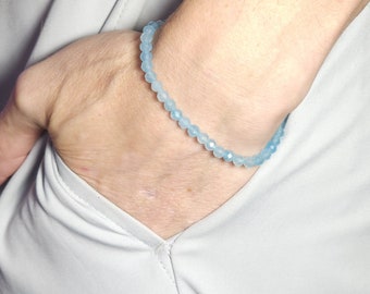 Pode incluir: Um bracelete de pedras preciosas azul claro com contas facetadas.