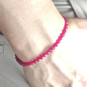 May include: A pink gemstone bracelet with faceted beads.