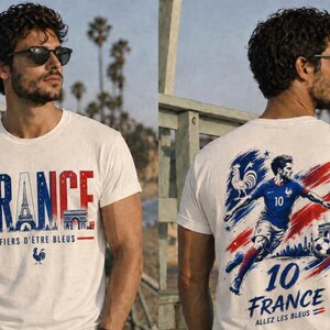 May include: White t-shirt with the word "FRANCE" in red and blue, featuring the Eiffel Tower and Arc de Triomphe. The front of the shirt also has the text "FIERS D'&Ecirc;TRE BLEUS" and a rooster. The back displays a soccer player and the text "10 FRANCE ALLEZ LES BLEUS".