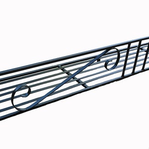 May include: Black metal window box with a decorative scroll design. The box is designed to be mounted on a wall.