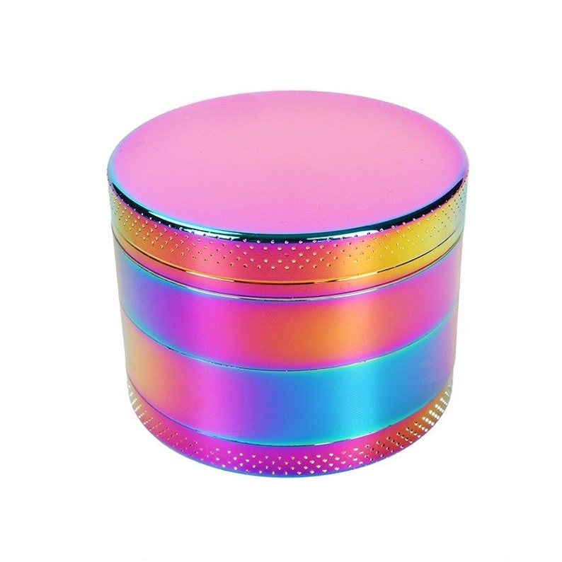 May include: A multi-colored metal grinder with a rainbow iridescent finish. The grinder has a textured top and a series of compartments.