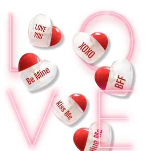 Puede incluir: Seis botellas de plástico transparente en forma de corazón con tapas rojas. Cada botella tiene un mensaje diferente impreso en ella: "Love You", "XOXO", "Be Mine", "Kiss Me", "BFF" y "Hug Me".