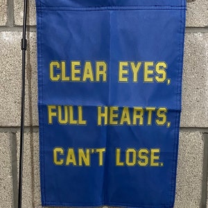 May include: A blue garden flag with the words "CLEAR EYES, FULL HEARTS, CAN'T LOSE." in yellow lettering.